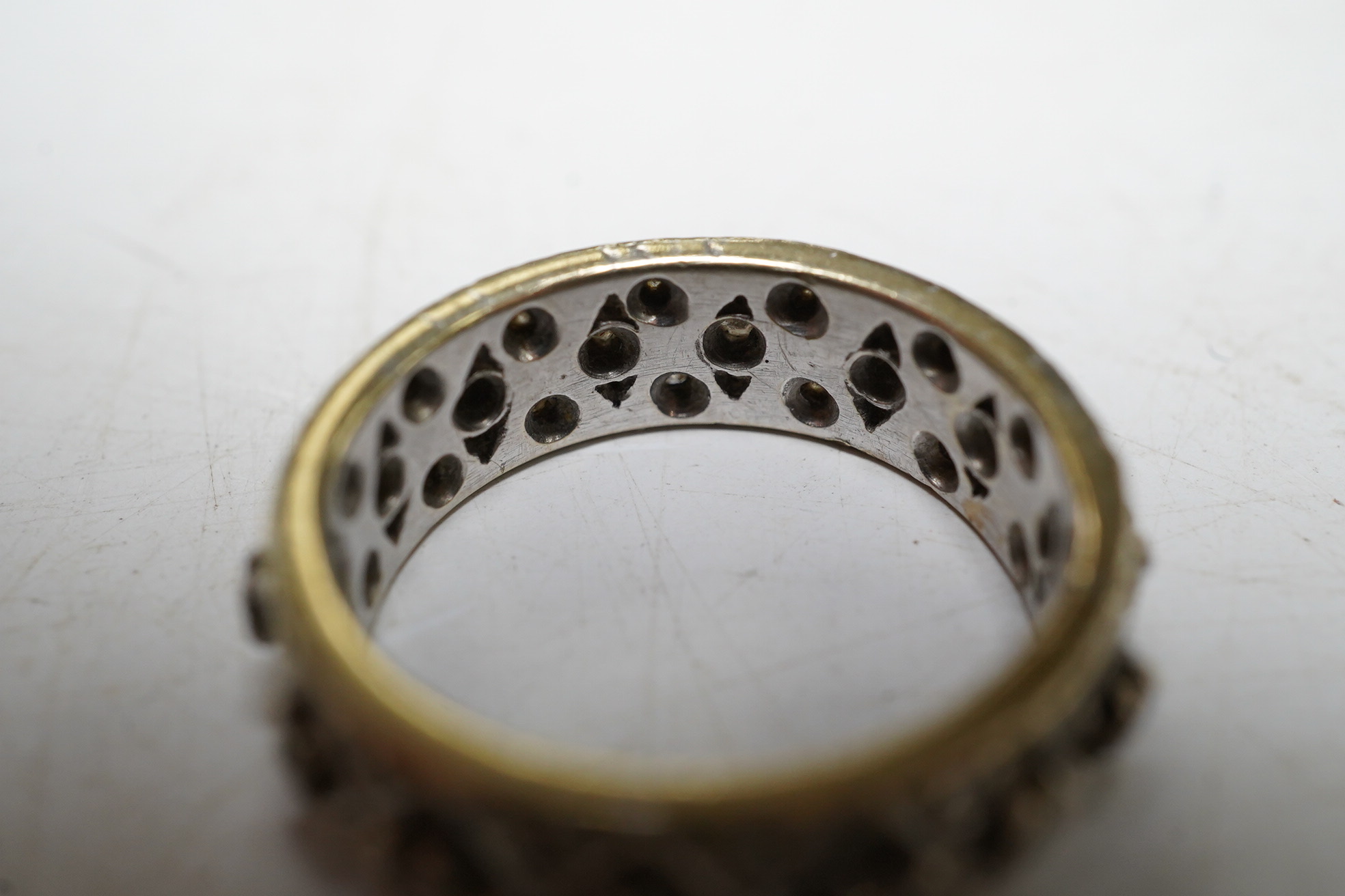 A diamond set white gold full eternity ring, size J, gross 4.7 grams. Condition - wear to the edges and one stone missing